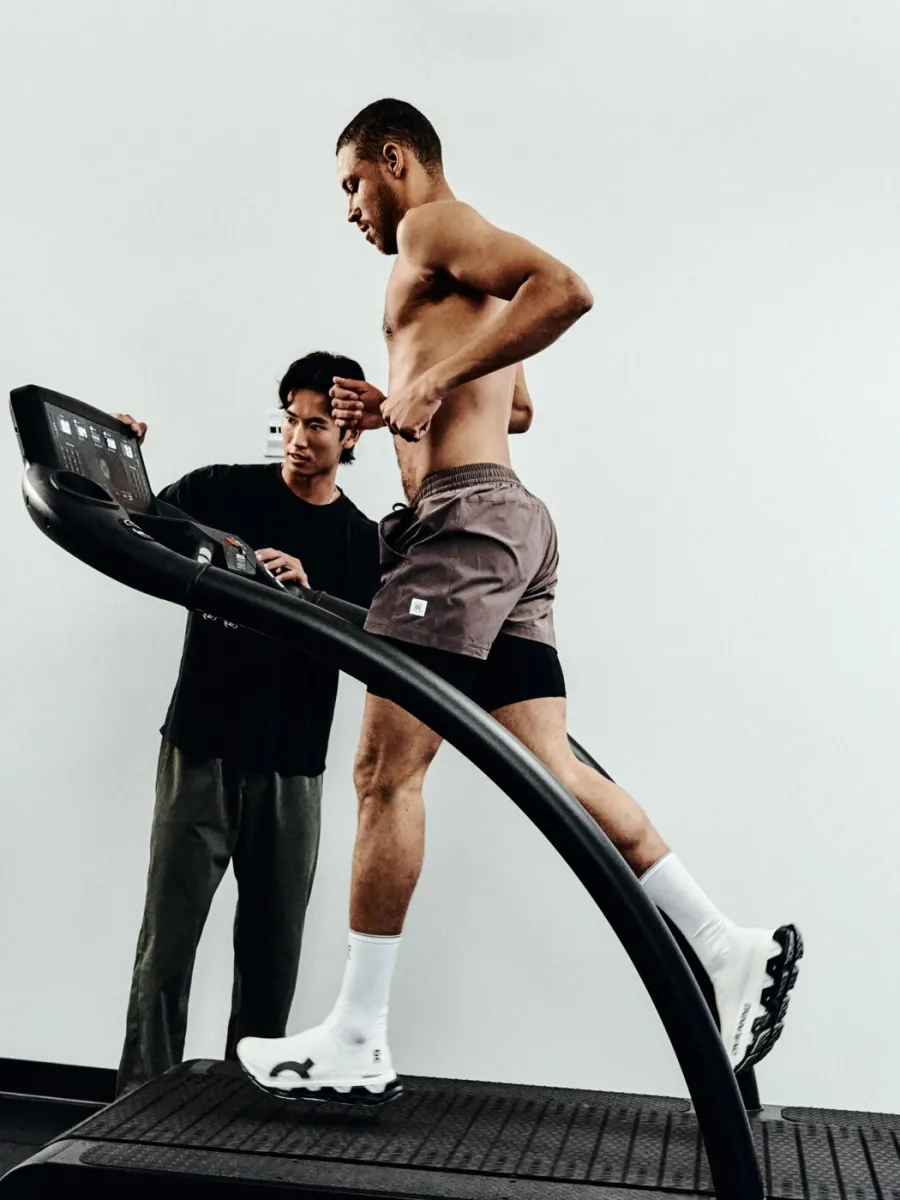 A physiotherapist reviewing a runner on a treadmill during a movement assessment